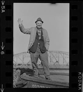 Man waving in front of bridge