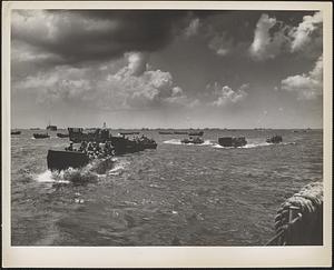 Swarms of coast guard-manned landing craft carry in marine and army troops to the shores of Saipan