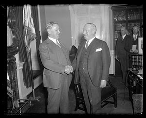 James M. Curley shaking hands with an unidentified man