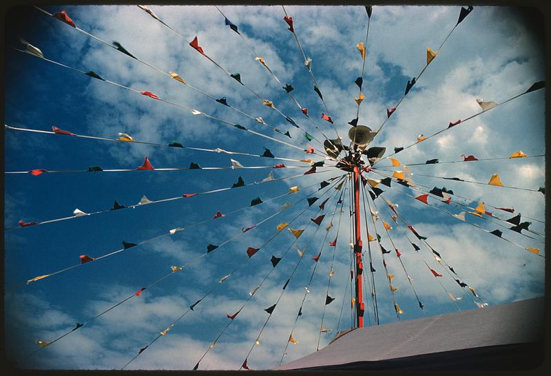 View looking up past roof to pole with radiating lines of pennants, Boston