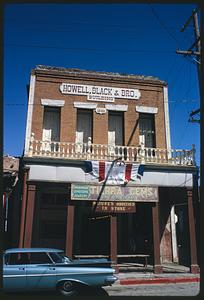 Front of Howell, Black & Bro. Building with Centennial banner hanging down, Virginia City, Nevada
