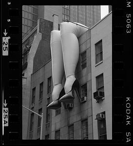 Inflatable legs hang from side of building, New York City
