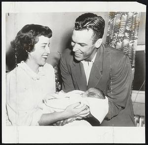 New Phillies Phan is wee Kathleen Ann Sisler, newly born daughter of Philadelphia Phillies outfielder Dick Sisler who is pictured with his wife at St. Mary's Hospital in Philadelphia. The Sislers also have a four-year-old girl.
