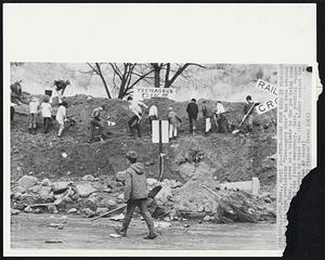 Teen-Agers Turn Hero in Minnesota Flood-A big sign proclaiming "Teen-agers Dike" has been erected Minn., levee as a tribute to the job being done the flood emergency. Here, youthful volunteers shovels to raise the dike higher against the