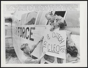 Members of the 435th Troop Carrier Wing based here, post a sign on the side of one of their C-119's, daring hurricane Cleo to "Try and Catch Us" as they prepare to evacuate the planes to Bakalar AFB, Ind., to escape the killer hurricane which is approaching South Florida. L-to-R: SSgt Bob Martin, Maj. Eugene Wheatly, and MSgt Louis Scalzo.