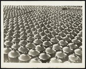 A Sea of Demijohns.. Medias , Rumania- It took many hours of "blowing" to get these glass demijohns into shape. The workmen in this factory here labor amid and intense heat, and can only work six hours a day. These demijohns are all ready to be shipped to pharmacists.