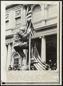 New York City Hall under Seige- Unidentified man wearing construction helmet raise half-staffed flag on standard outside New York's City Hall Friday after more than 1,000 persons, apparently angered by Mayor John V. Lindsay's antiwar stand, attempted to storm the building. The mayor had ordered the flag half-staffed because of the deaths of four Kent State students during a demonstration om Ohio. During the hour long fracas which ensued. Construction workers attacked and beat students in a college building nearby. Eleven students were hospitalized.