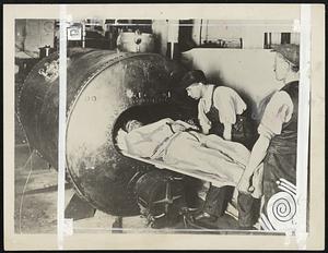 Men engaged in one of the most hazardous tasks, that of deep-sea diving, are given a very rigid test and training before they undertake their jobs. This photo taken in London shows a demonstration of the use of a compression chamber. If a diver comes up too quickly from a great depth he is afflicted with Caisson disease which may well prove fatal-as it is a type of paralysis-unless instantly treated. He is put into this chamber under an air pressure equal to that at the lowest depth to which he has been and the pressure is then very gradually decreased. In most cases this treatment restores the diver to normal health.