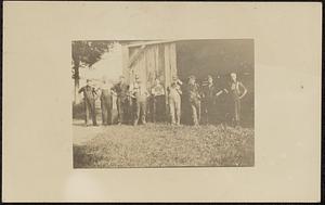 Group of workers in front of workshop or barn