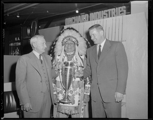 Man being given an award by man dressed as Indian Chief. Orchard Industries.