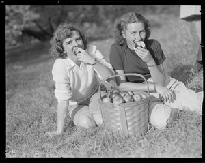 Two women eating apples