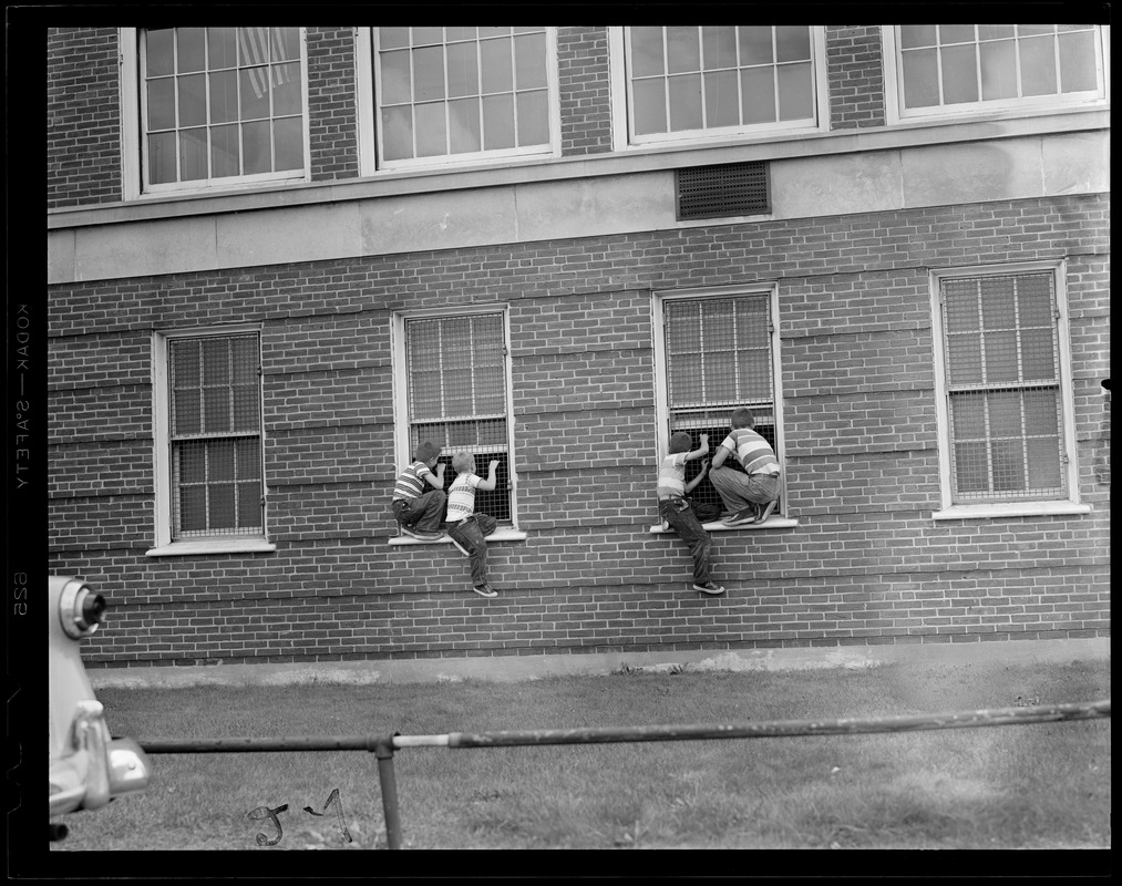 4 kids peering through 2 windows