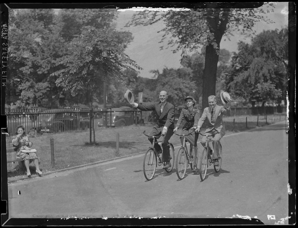 Two men and uniformed woman riding bikes