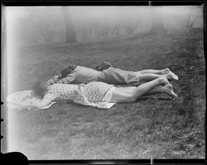 Two women sleeping on grass