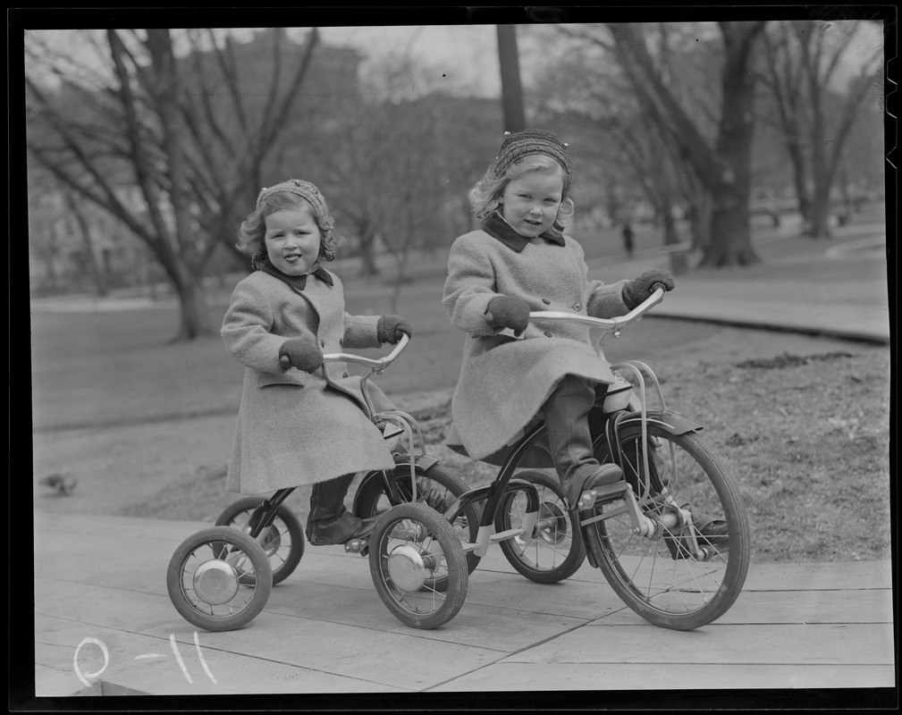 2 girls on tricycles