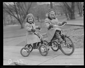 2 girls on tricycles