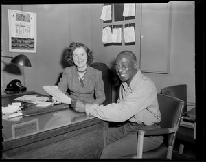Man & woman at desk (Man is African-Amer.)