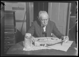Man examining old newspapers.