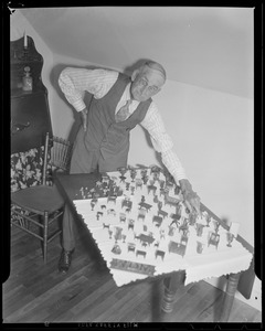 Old man with collection of miniature furniture