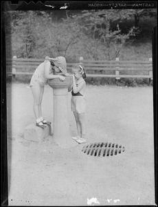 Girls at water fountain in park
