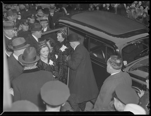 Three unidentifed women exiting automobile in crowd