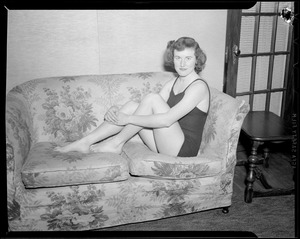 Girl poses in bathing suit on love seat