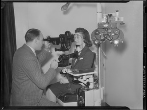 Optometrist Dr. Russell W. Johnson examines eyes of Anne Cohen of Roxbury at New England Optometrist's congress at Hotel Statler.