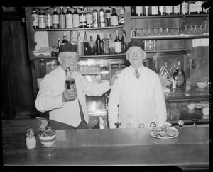 Martin Leonard, age 74, Andy Harrington, age 80, behind bar opening oysters