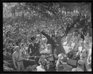 Mayor Tobin and Dorothy Lamour wave to crowds of soldiers from the back of auto