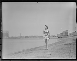 Connie Peck, fashion model, walking on beach in flowered bathing suit