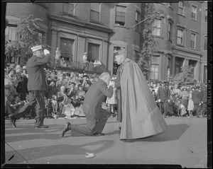 Man kisses hand of Cardinal Cushing during procession