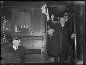 Gov. Curley waves his hat to photographer from train