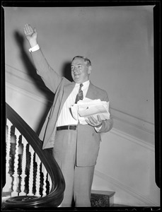 Curley salutes from his staircase at home