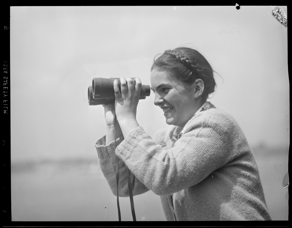 Woman with binoculars at sporting event