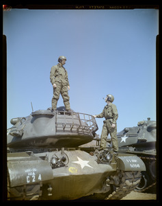Two soldiers standing on tank