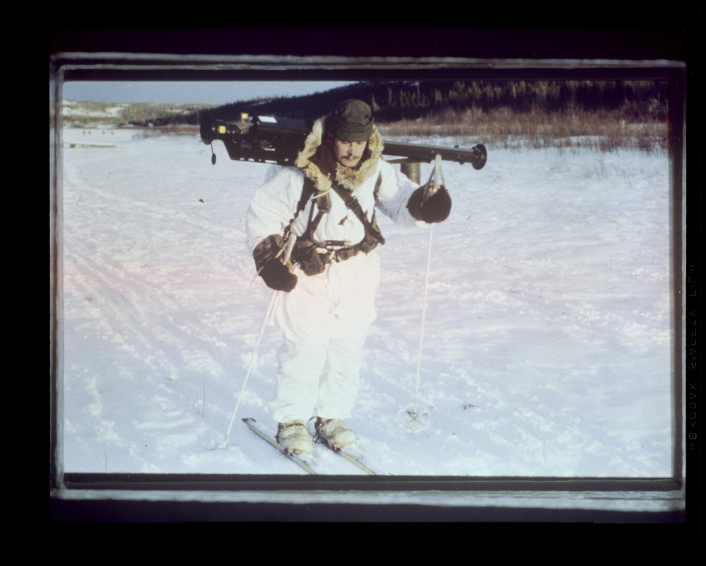 Man on skis carrying equipment