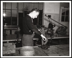 N.Y.A. student aid recipient making metal plant containers at State Teachers College