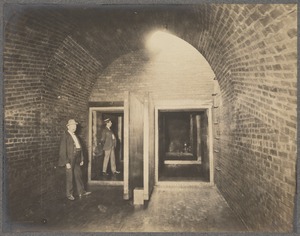 Men standing in divided sewer