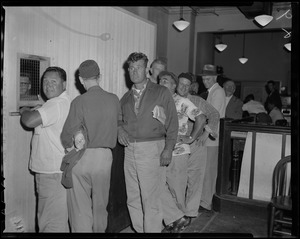 Line of men standing at the window