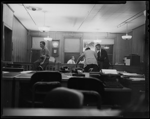 View from the desk, looking at five men in the room