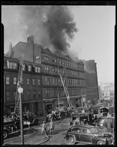 Building on fire with fire department ladders