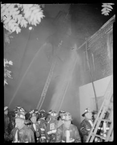 Fire fighters' hoses spraying a building