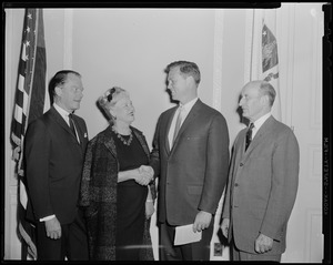 Man and woman shaking hands as two other men look on