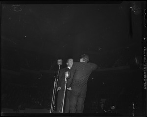 Two men on stage, behind microphones