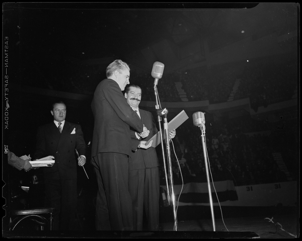 Acting Mayor of Boston John E. Kerrigan shaking hands and presenting award to Jerry Colonna while Bob Hope looks on