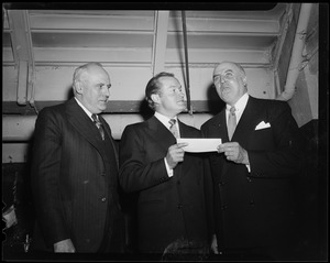 Two men and Bob Hope posing, with one  man handing an object to Bob Hope