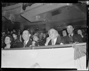 Men seated in crowd, laughing