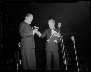Acting Mayor of Boston John E. Kerrigan presenting object, possibly a symbolic key, to Bob Hope on stage
