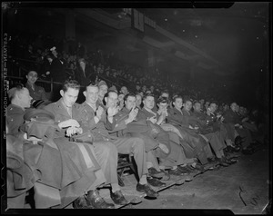 Seated crowd of military men in uniform, some clapping