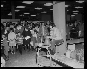 Man on a pottery wheel, demonstrating the process to a crowd